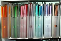 several different colored pens are lined up on a shelf