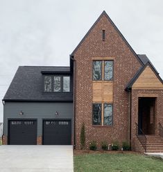 a large brick house with two garage doors