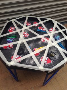 a round table with many stickers on it in front of a garage door,