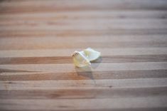 a peeled piece of food sitting on top of a wooden cutting board