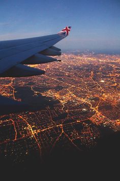 an airplane wing flying over a city at night