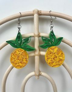 the earrings are made out of paper and have green leaves on them