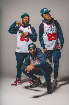 three men in matching outfits posing for a photo