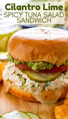 a close up of a sandwich on a cutting board with potato chips in the background