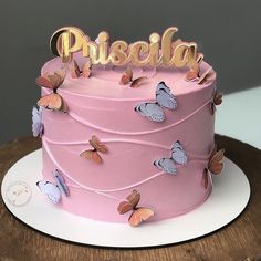 there is a pink cake with butterflies on it and the word piscella spelled in gold