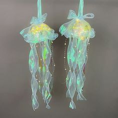 there are two jellyfishs hanging from the ceiling with lights on it's sides