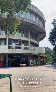 an image of a building that is in the middle of a park with people walking around it