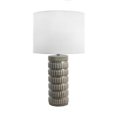 a lamp that is sitting on top of a white table cloth next to a stack of coins