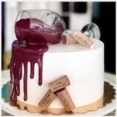 a white cake with wine corks on top and red liquid pouring down the side