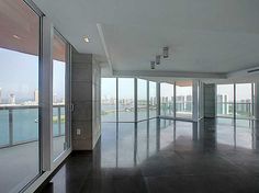 an empty room with large windows overlooking the city