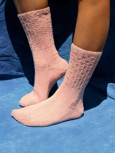 a woman's legs wearing pink socks and holding a tennis racquet