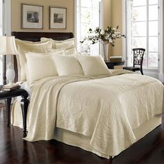 the comforter is made up with white sheets and pillowcases, along with matching pillows