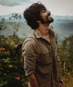 a man standing on top of a lush green hillside