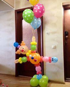 a bunch of balloons that are hanging from a pole in front of a door with the words happy birthday written on it