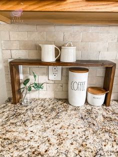 a counter top with coffee mugs on it and a wooden shelf above the counter