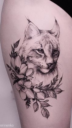 a black and white photo of a cat with flowers on it's side thigh