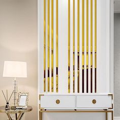 a living room with white furniture and yellow striped curtains on the wall behind it, along with a small side table