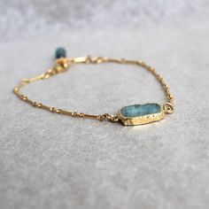 "Subtle shades of tropical waters in pale blue and bright gold,  These rough slices of aquamarine are dipped in gold plate.  Bracelet chain and  clasp are all gold filled.  A delicate gold-filled wrapped aquamarine stone finishes the bracelet.  Adjustable size 7\"-8\" The earrings can be purchase separately at https://www.etsy.com/listing/1163103992/rough-cut-aquamarine-with-gold-dangles?click_key=a8a3c24b59a65ea05319c8bce692c0718c5b2a90%3A1163103992&click_sum=b772d68a&ref=shop_home_active_5&frs Dainty Aquamarine Gold Jewelry, Gold Amazonite Bracelet Jewelry, Gold Amazonite Bracelet, Amazonite Bracelet Jewelry In Gold, Gold Aquamarine Jewelry With Natural Stones, Elegant Gold Aquamarine Bracelet, Minimalist Gold Aquamarine Jewelry, Gold Aquamarine Bracelet Gift, Adjustable Gold Amazonite Jewelry