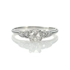 a white gold engagement ring with an oval cut diamond in the center and two small round diamonds on each side