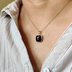 ITEM DESCRIPTION: >>The pendant is made from Solid 14K Yellow Gold. Gemstone used is absolutely natural and ethically sourced. >>Natural Black Onyx in bezel setting is studded on it with utmost precision. >>This is a minimalist design and is absolutely hassle-free and everyday jewelry. Gem: Black Onyx Gem size: 12x12 mm Gem weight: 6.68 carats Gold purity: 14K (58.33% approx.) Gold weight: 0.59 grams Gross weight: 1.93 grams The Gold purity is guaranteed and it comes with authentic 14K gold hall Black 14k Gold Jewelry With Bezel Setting, Yellow Gold Black Spinel Jewelry As A Gift, Black Onyx Pendant Jewelry, Fine Jewelry Black Necklace With Black Enamel, Black Spinel Jewelry With Polished Finish, Black Pendant Jewelry For Anniversary, Classic Black Spinel Jewelry Gift, Black Enamel Necklace For Anniversary, Classic Black Necklace For Anniversary