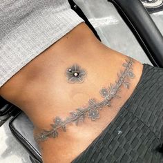 a woman's lower back tattoo with flowers on it