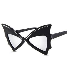 The Bat Diva Sunglasses Spooky Bat Diva sunglasses - retro, pin-up style sunnies with bat wings and studs. Gives any outfit that effortlessly vintage horror look! Material: PVC Plastic. Total Width: 147mm Lens Width: 52mm/Height: 37mm Arm Length: 143mm Retro Plastic Cat Eye Sunglasses For Party, Trendy Halloween Festival Sunglasses, Punk Style Mirrored Sunglasses For Summer, Retro Cat Eye Sunglasses With Mirrored Lenses For Party, Punk Style Sunglasses For Summer Festivals, Party Cat Eye Sunglasses With Mirrored Lenses, Retro Cat Eye Sunglasses For Summer Party, Black Retro Sunglasses For Festival, Retro Black Sunglasses For Festival