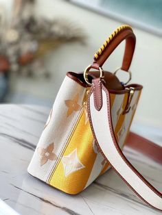 Made from colorful striped canvas with natural leather trim, this adorable Capucines BB handbag has a two-color braided leather top handle as well as a wide removable strap. The embroidered Monogram flowers motif on the edges of the summery stripes adds the final touch of Louis Vuitton style. Detailed Features 27 x 18 x 9 cm (Length x height x width ) Yellow Smooth calfskin and embroidered canvas Smooth-calfskin and embroidered-canvas trim Cowhide lining Gold-color hardware Double carry style: f Capucines Louis Vuitton, Tas Louis Vuitton, Louis Vuitton Capucine, Louis Vuitton Taschen, Louis Vuitton Capucines, Lady Bags, Embroidered Canvas, Embroidered Monogram, Coach Bag