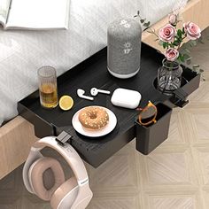 a table with some food and headphones on it next to a vase filled with flowers