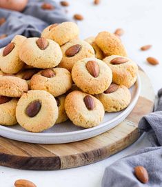 almond cookies on a plate with nuts scattered around