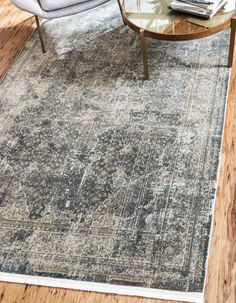 a living room area with a rug, chair and coffee table