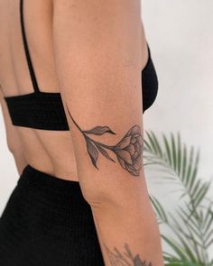 a woman's arm with a flower tattoo on the left side of her body