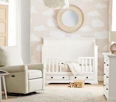 a baby's room with a white crib, chair and mirror on the wall