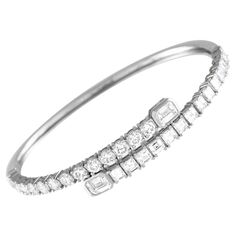 This elegant 18K white gold bracelet seemingly wraps around the wrist. Incredibly eye-catching, the simple setting comes to life thanks to Ascher cut diamonds totaling 3.40 carats, emerald cut diamonds totaling 1.40 carats, and additional diamond accents with a total weight of 2.60 carats. It measures 7.0 long and comes complete with secure tab insert clasp closure.This jewelry piece is offered in brand new condition and includes a gift box. Ascher Cut, Modern Bangle, White Gold Bangle, Modern Bracelets, Luxury Bracelet, Gold Armband, White Gold Set, White Gold Bracelet, Bezel Set Diamond