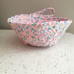 a pink and blue basket sitting on top of a table