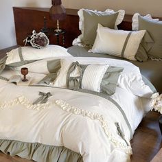 a bed with white and grey comforters on top of it