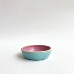 a blue and pink bowl sitting on top of a white table