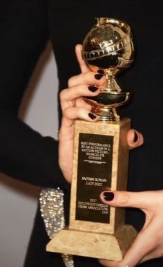 a woman holding an award in her hands