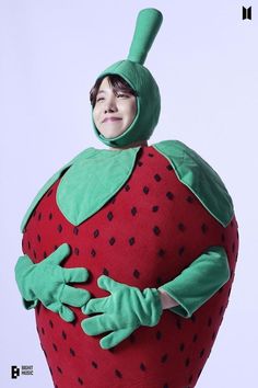 a person in a costume that looks like a strawberry with hands on the back of it