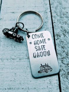 a metal keychain that says come home safe daddy with a toy car on it