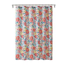 a floral shower curtain hanging on the side of a bathtub in front of a white wall