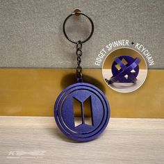 a keychain with a purple paper cut out of the shape of a house