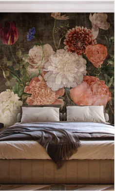 a bed sitting in front of a wall with flowers on it