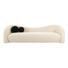 a white couch with two black balls on it's back and the seat upholstered