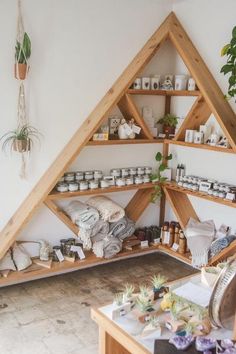 a wooden shelf filled with lots of items next to a wall mounted potted plant