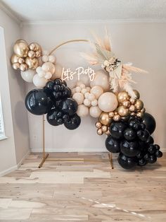 black and gold balloons are arranged in the shape of a arch