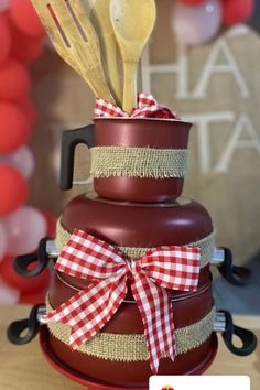 a stack of pots and pans with utensils in them