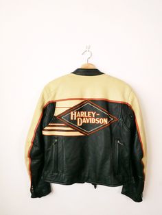 harley davidson leather jacket hanging on a white wall with the words harley davidson printed on it