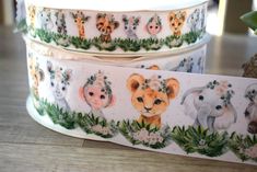 two rolls of washi tape with animals on them and flowers around the edges, sitting on a wooden surface