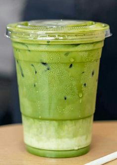 a green drink with black spots on it