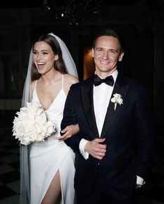 a man and woman in formal wear standing next to each other smiling at the camera